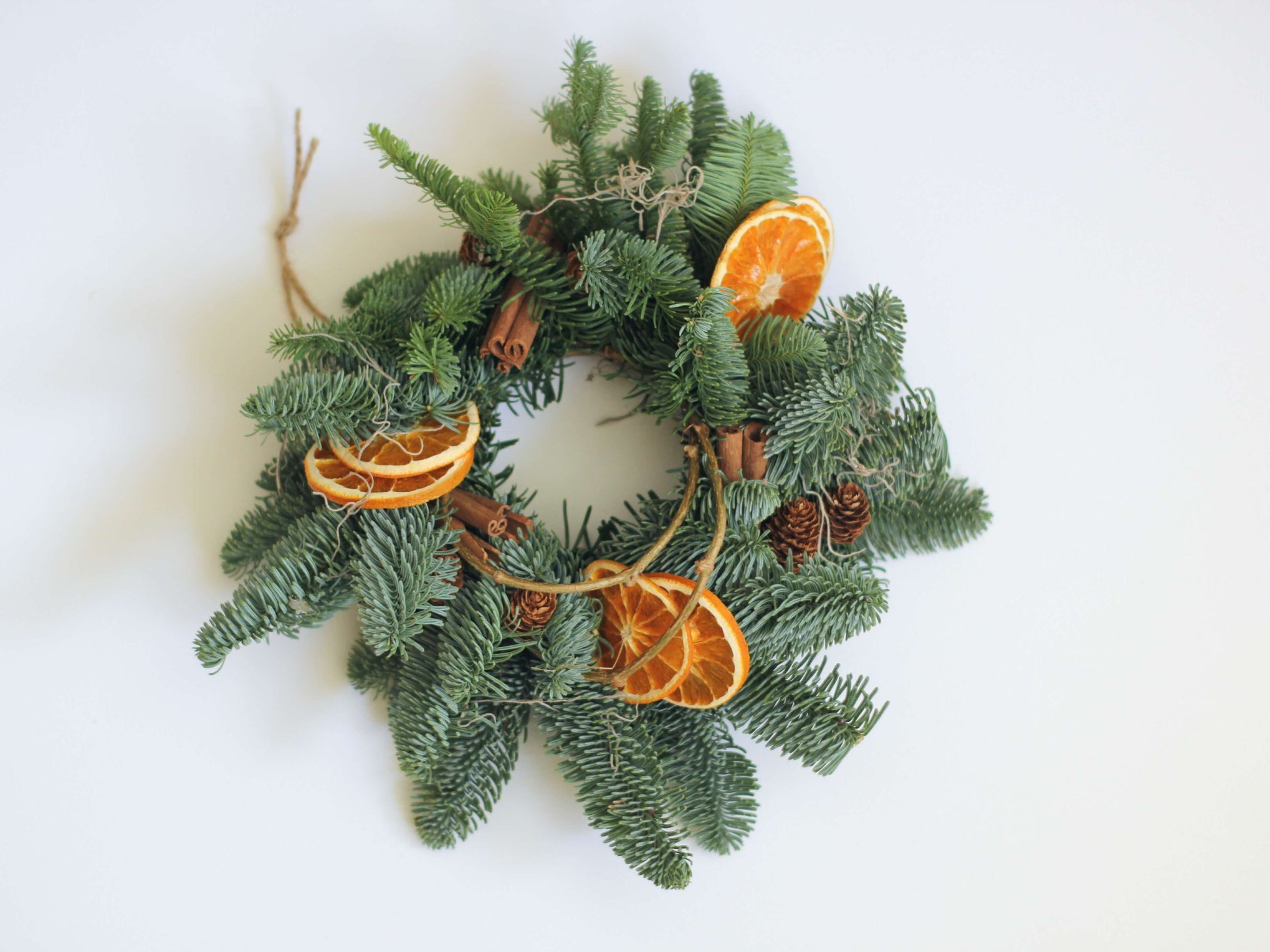 Coroniță naturală festivă decorată cu scorțișoară, portocale și conuri
